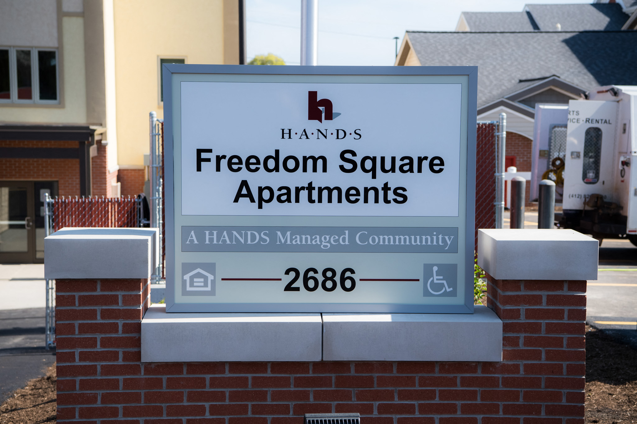 a sign for freedom square apartments in front of a house